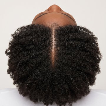 Top-down view of thick, healthy natural hair with a full part